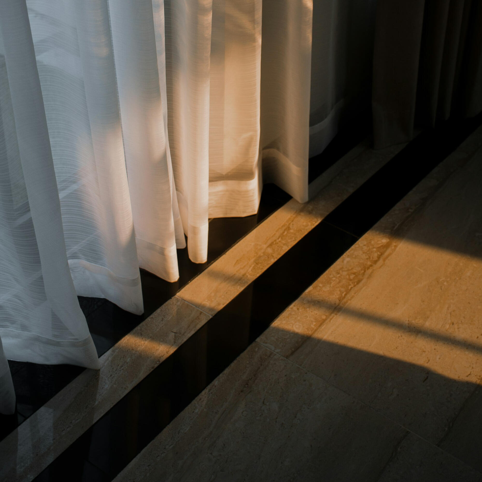 ventana con cortinas iluminadas por el sol, metáfora de transparencia en precios web para alojamientos